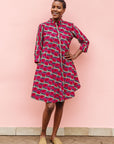 Model wearing red and pink geometric print dress.
