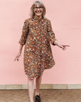 Model wearing brown, black and white pebble print dress.