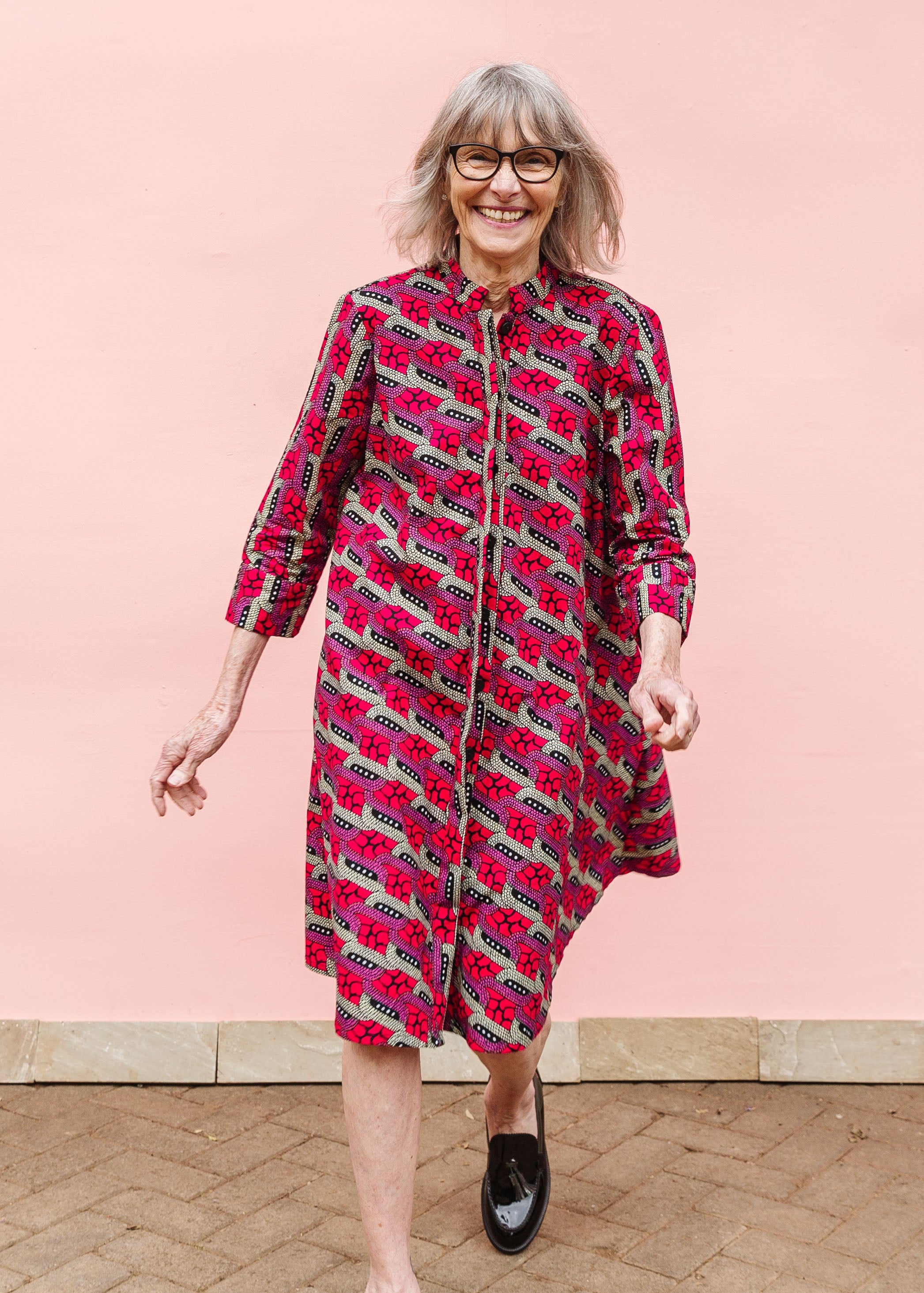 Model wearing red and pink geometric print dress.