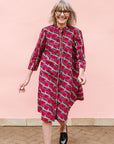 Model wearing red and pink geometric print dress.