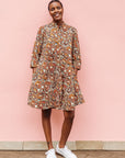 Model wearing brown, black and white pebble print dress.
