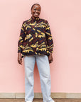 Model wearing long sleeve blouse with brown and yellow abstract print.