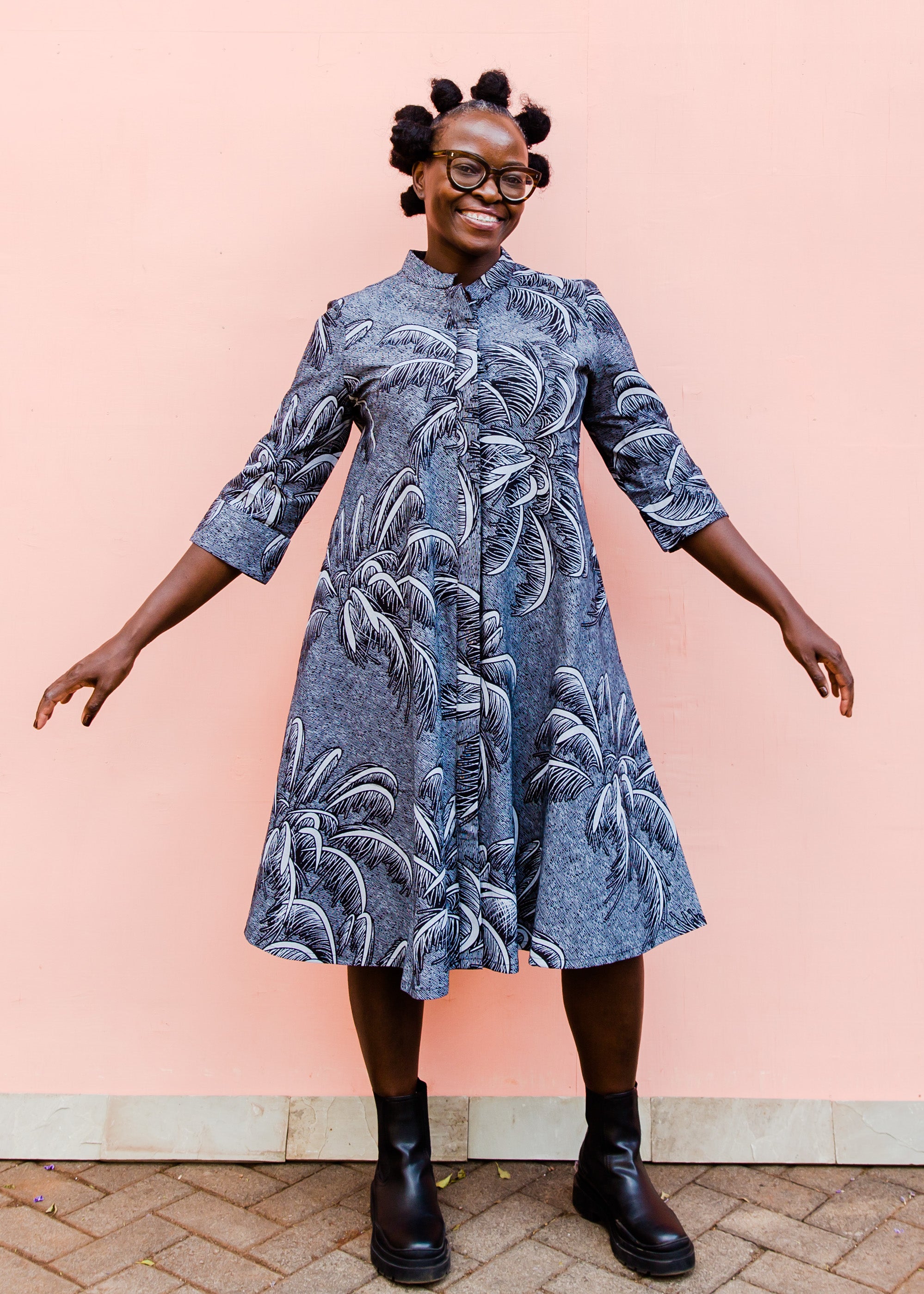 model wearing a black and white palm tree design dress