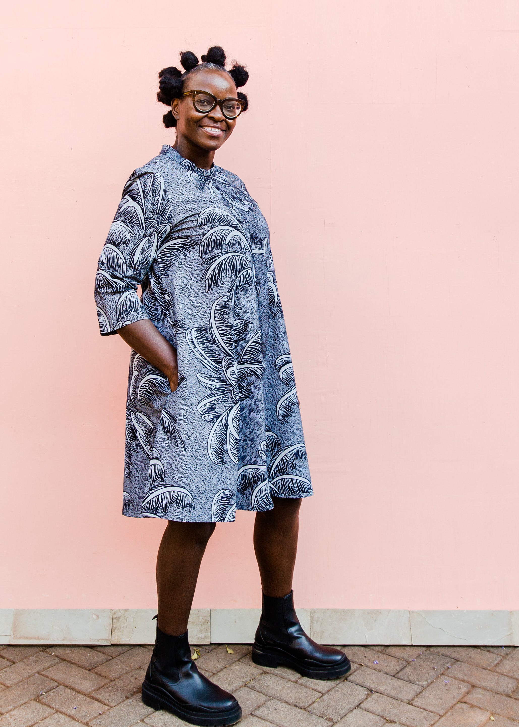 model wearing a black and white palm tree design dress