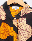 Display of orange, beige and black leaf print dress.