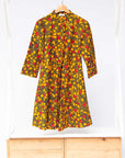 Display of black dress with yellow and red small blob print.