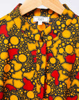 Display of black dress with yellow and red small blob print.