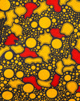 Close up display of black dress with yellow and red small blob print, fabric.