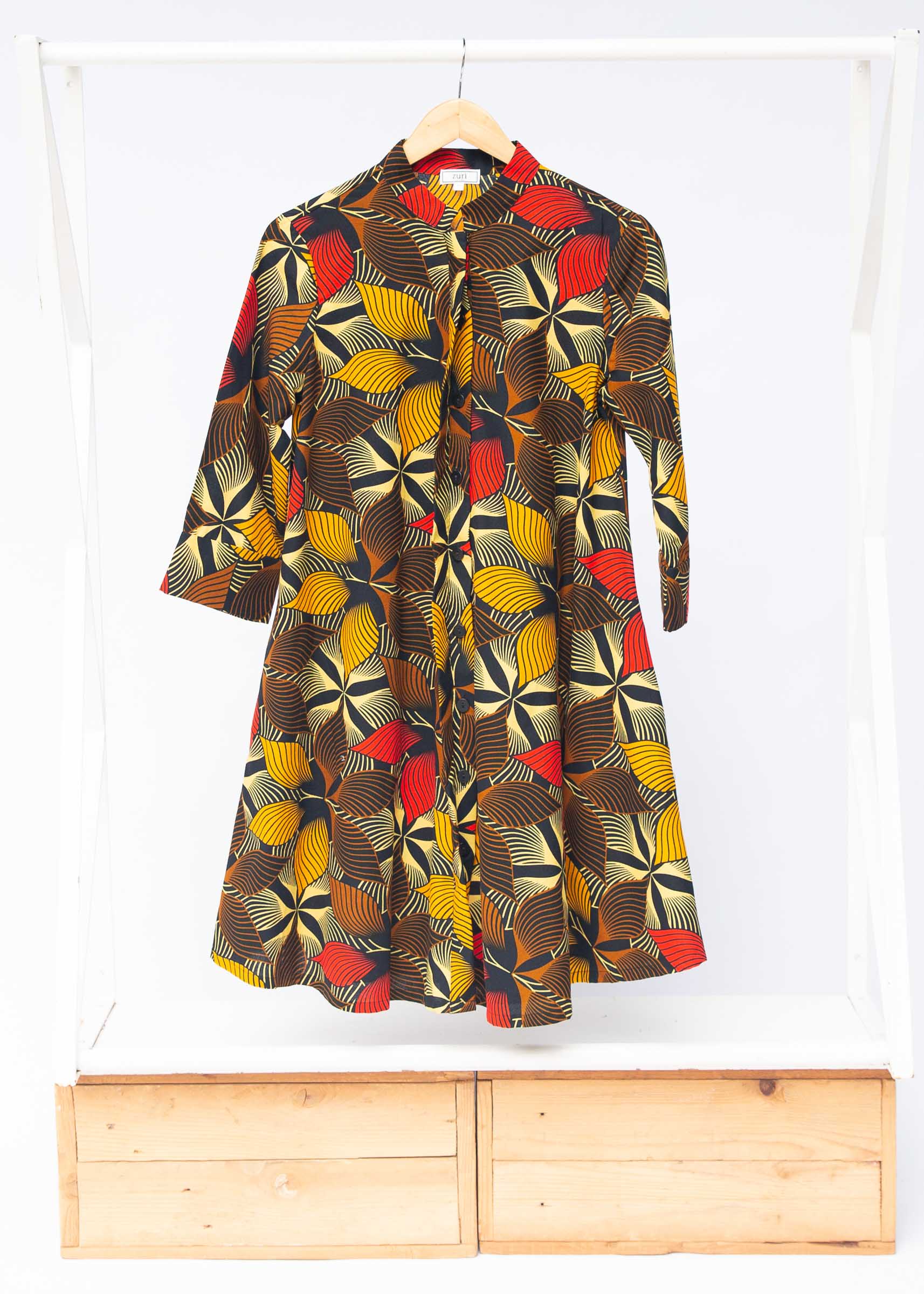 The display of brown, yellow, red and black leaf print dress.