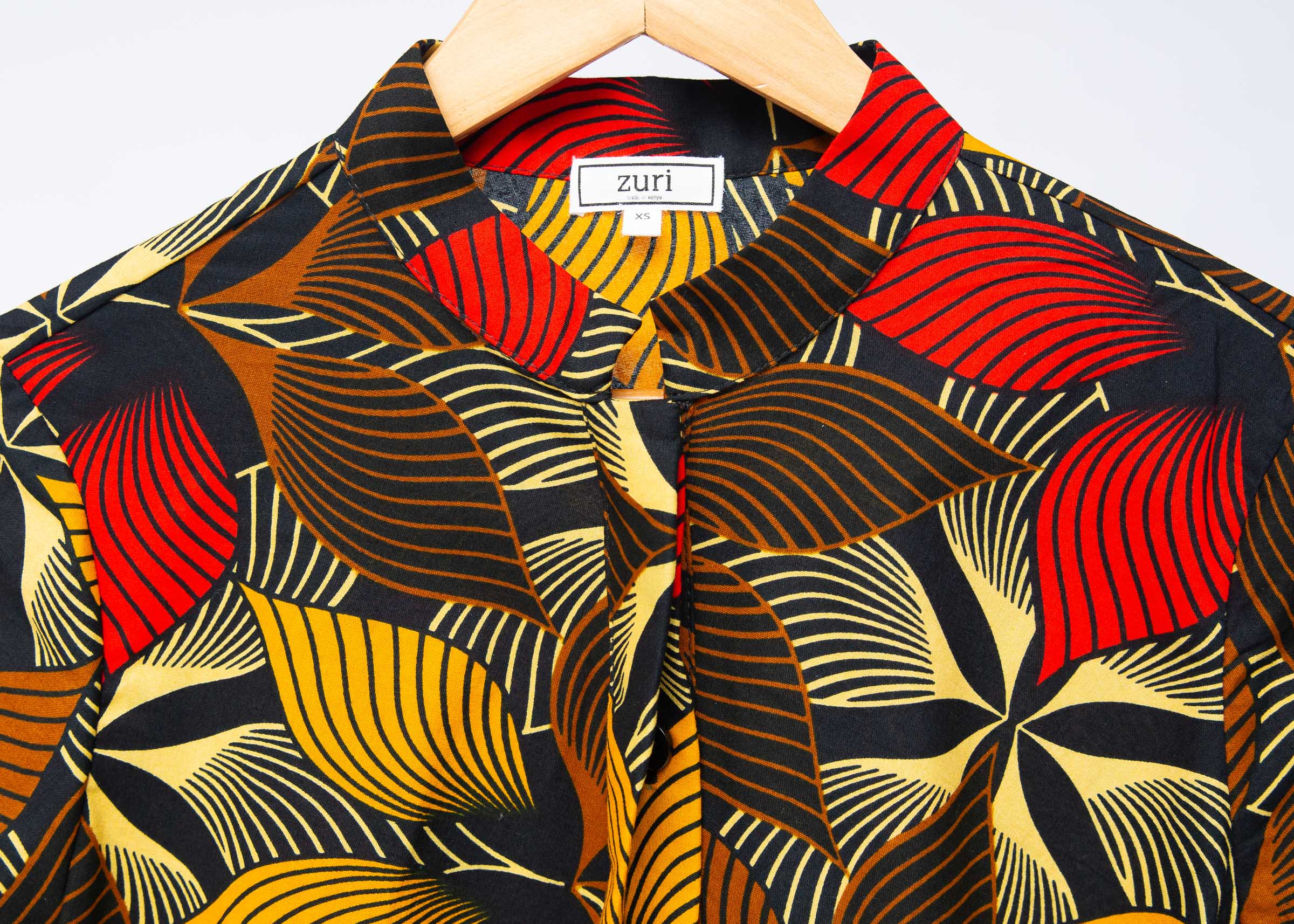 The display of brown, yellow, red and black leaf print dress.