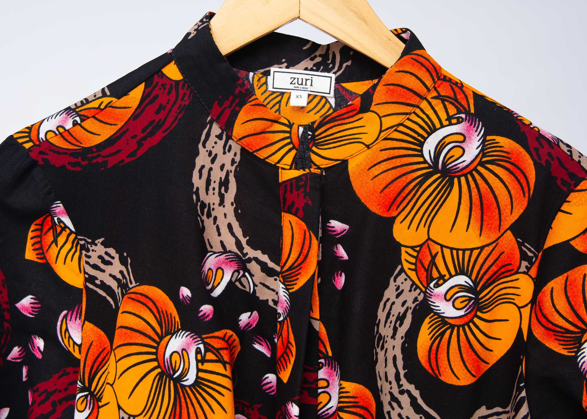 Display of black dress with yellow and pink floral print.