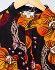 Display of black dress with yellow and pink floral print.