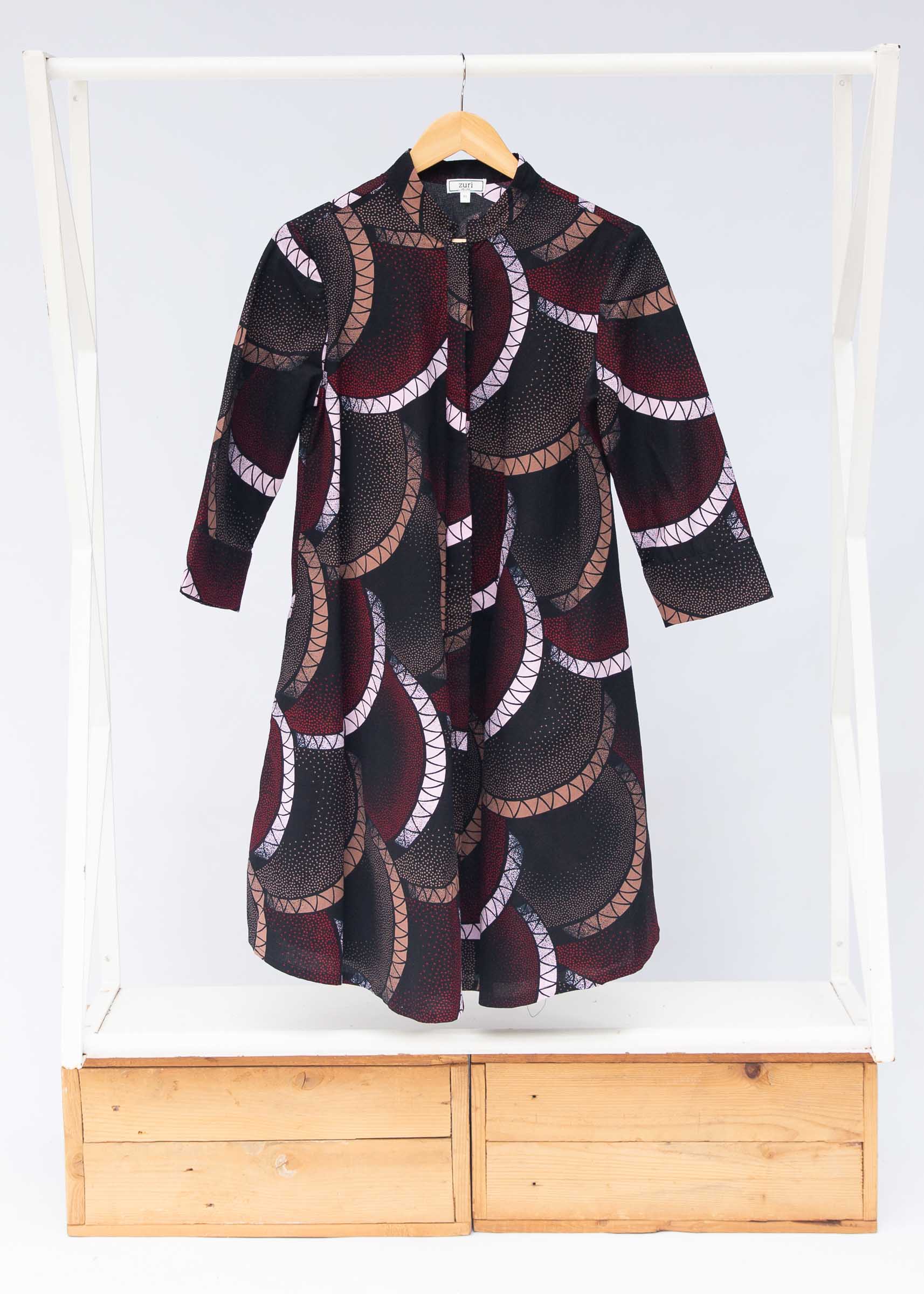 Display of red, beige, white and black geometric print dress.