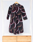 Display of red, beige, white and black geometric print dress.
