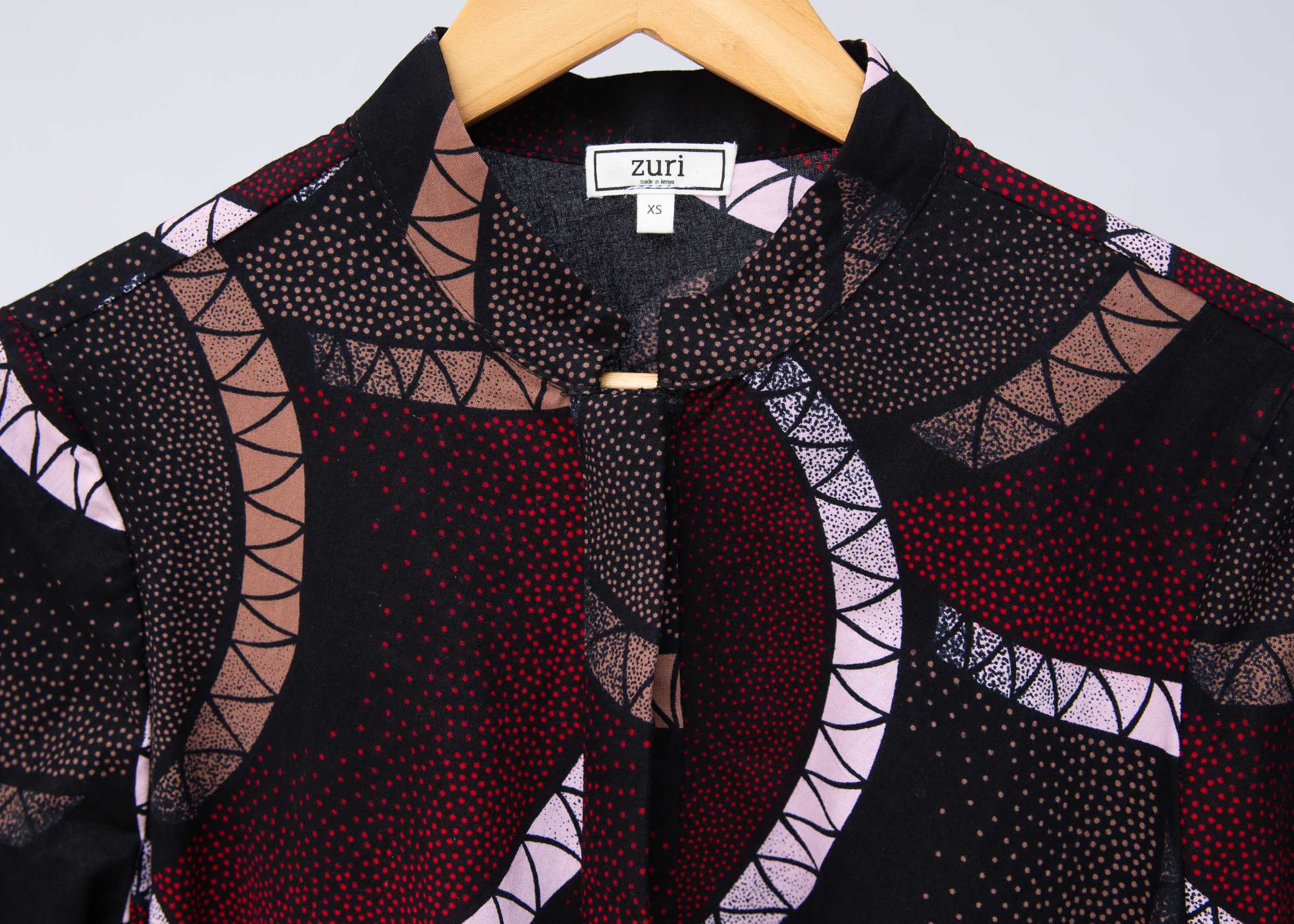 Display of red, beige, white and black geometric print dress.