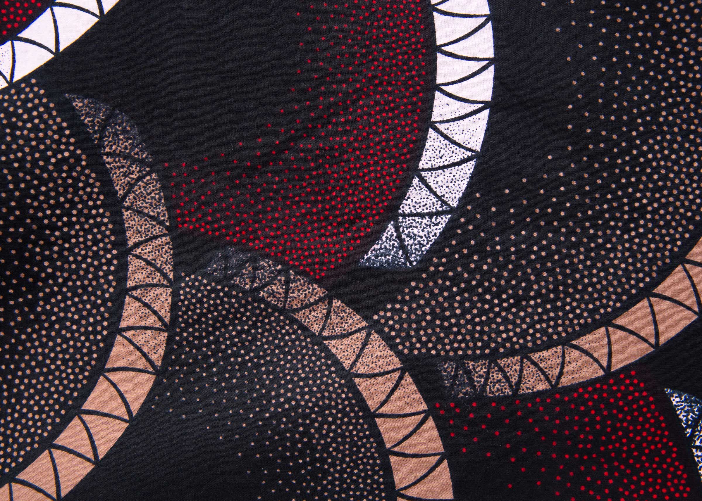 Close up display of red, beige, white and black geometric print dress, fabric.