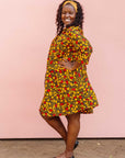 The model is wearing black dress with yellow and red small blob print.