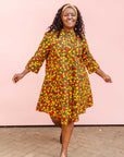 The model is wearing black dress with yellow and red small blob print.