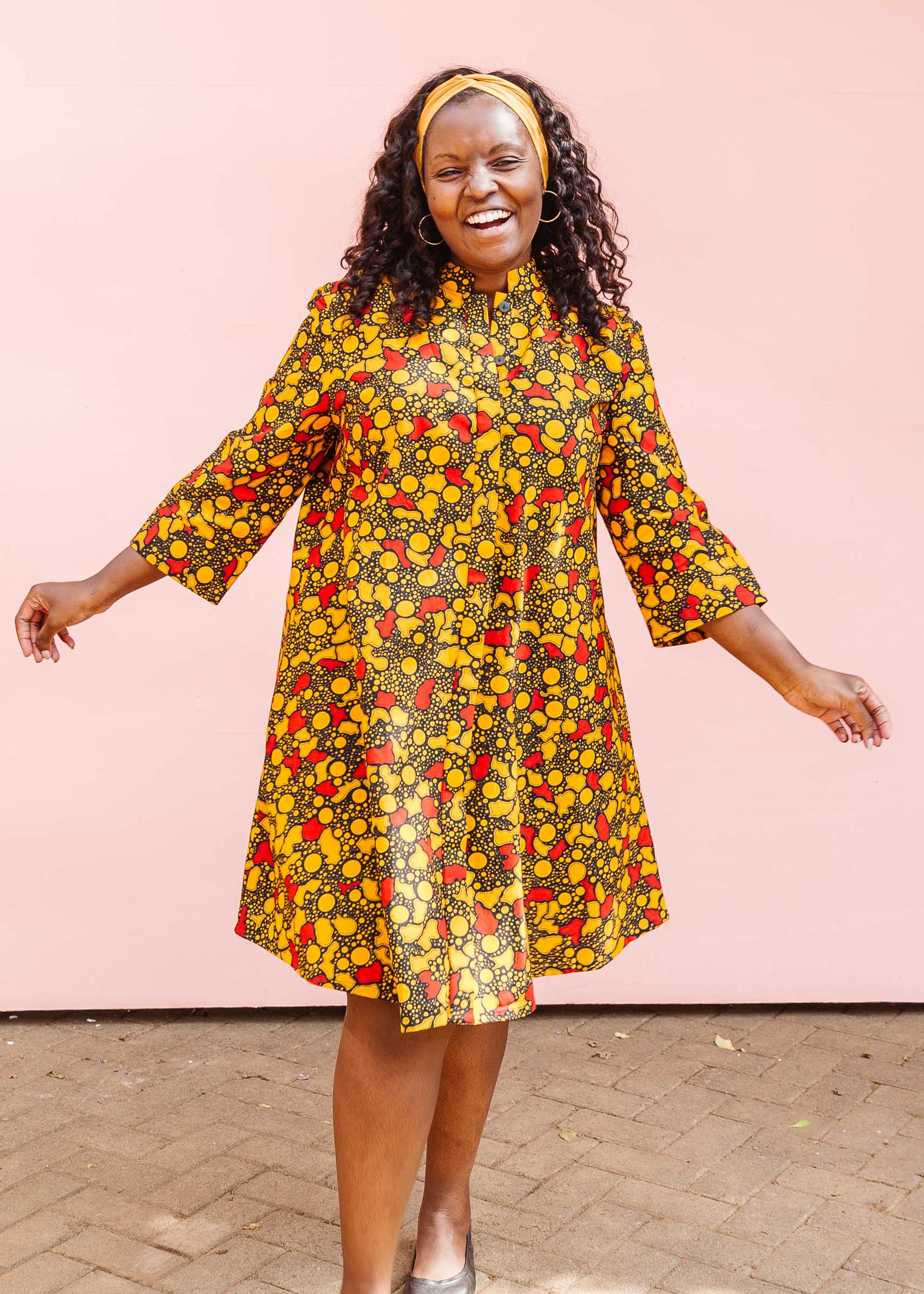 The model is wearing black dress with yellow and red small blob print.