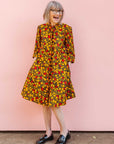 The model is wearing black dress with yellow and red small blob print.