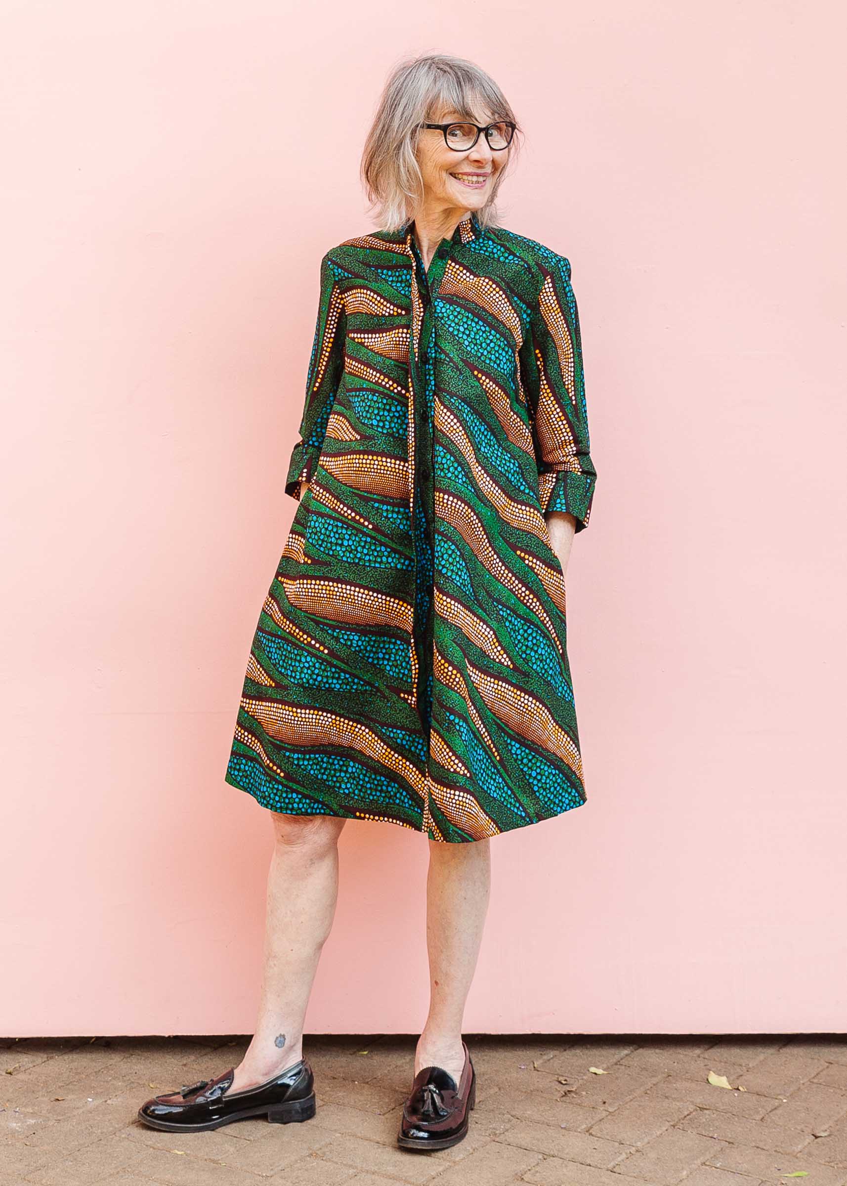 The model is wearing blue, green and orange abstract line dress.