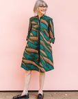 The model is wearing blue, green and orange abstract line dress.