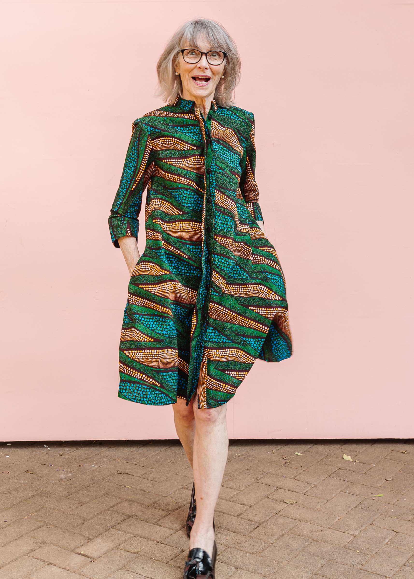 The model is wearing blue, green and orange abstract line dress.