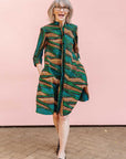 The model is wearing blue, green and orange abstract line dress.