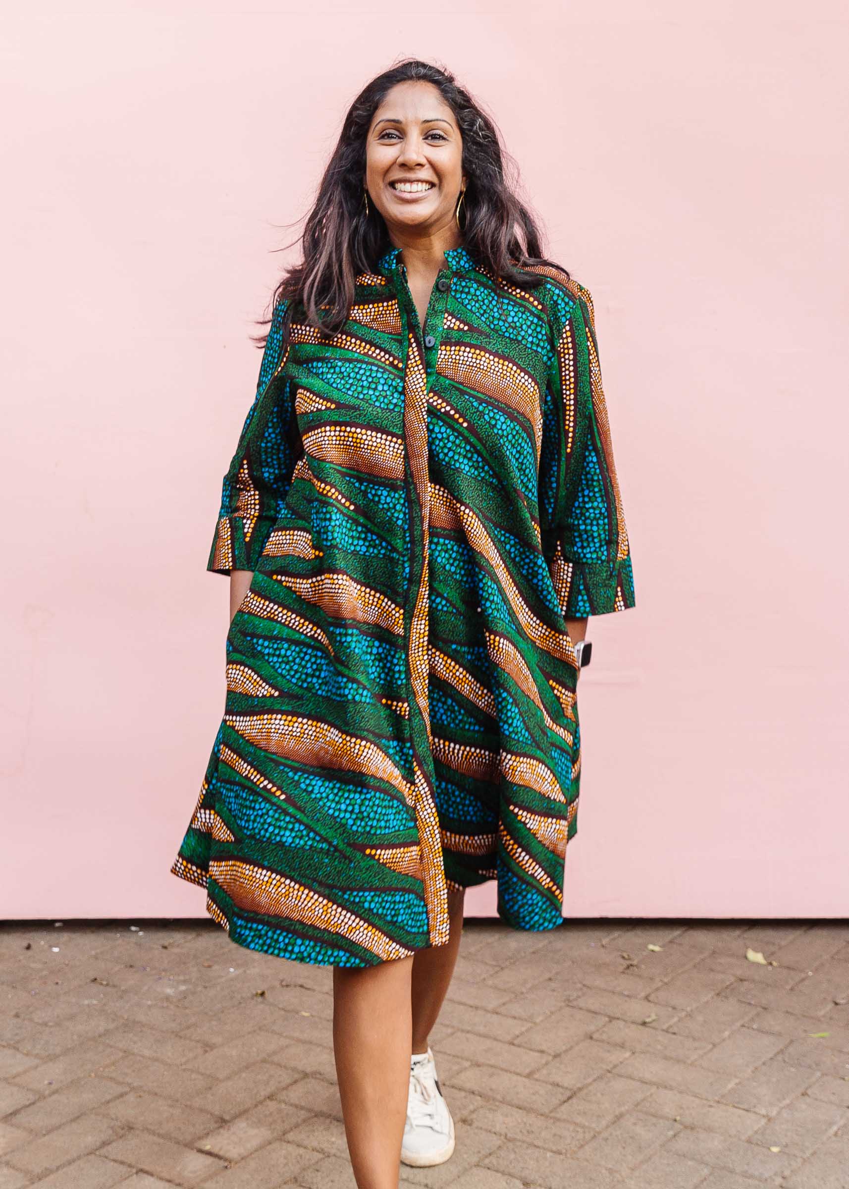 The model is wearing blue, green and orange abstract line dress.