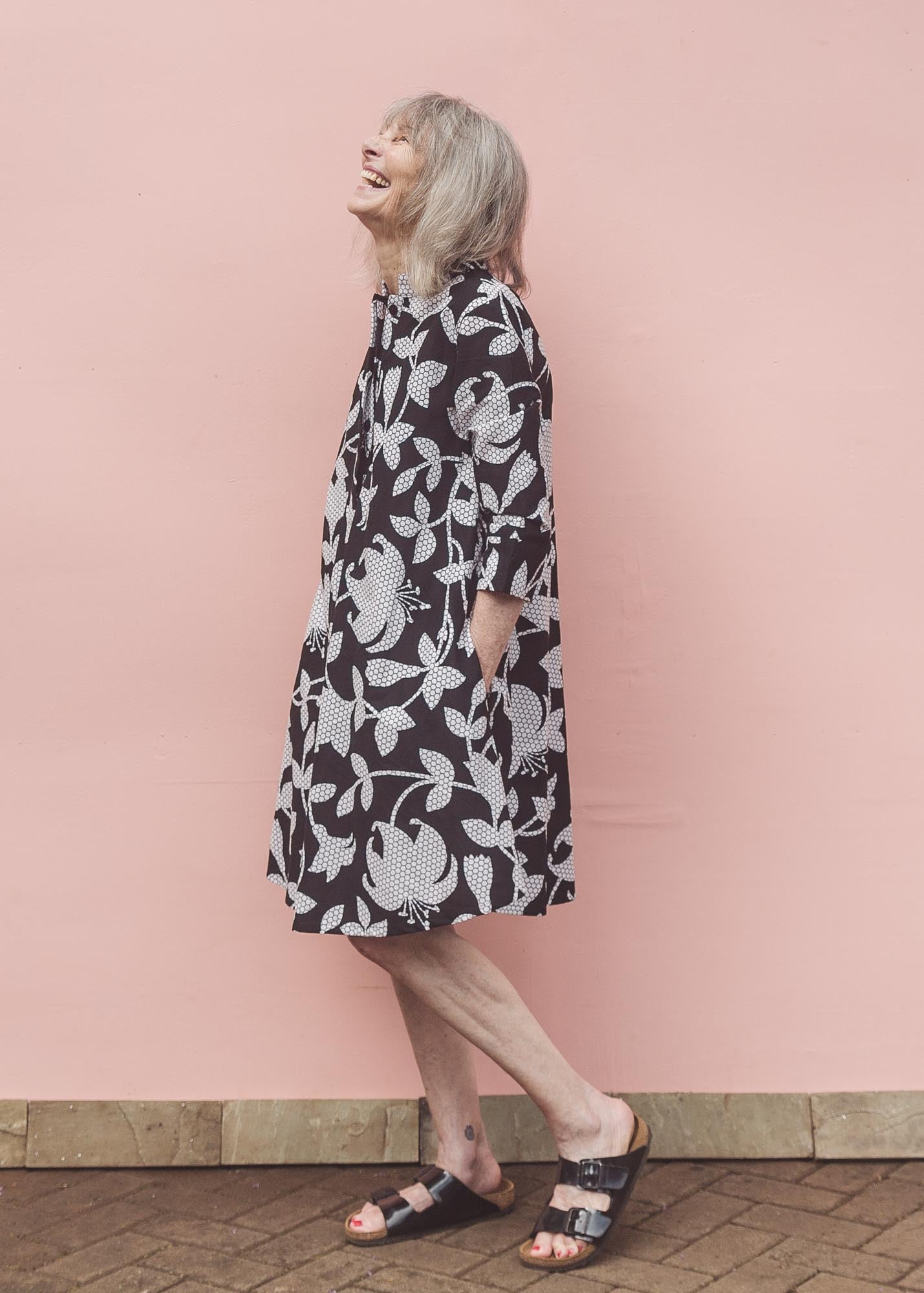 The model is wearing black dress with white and gray leaf print