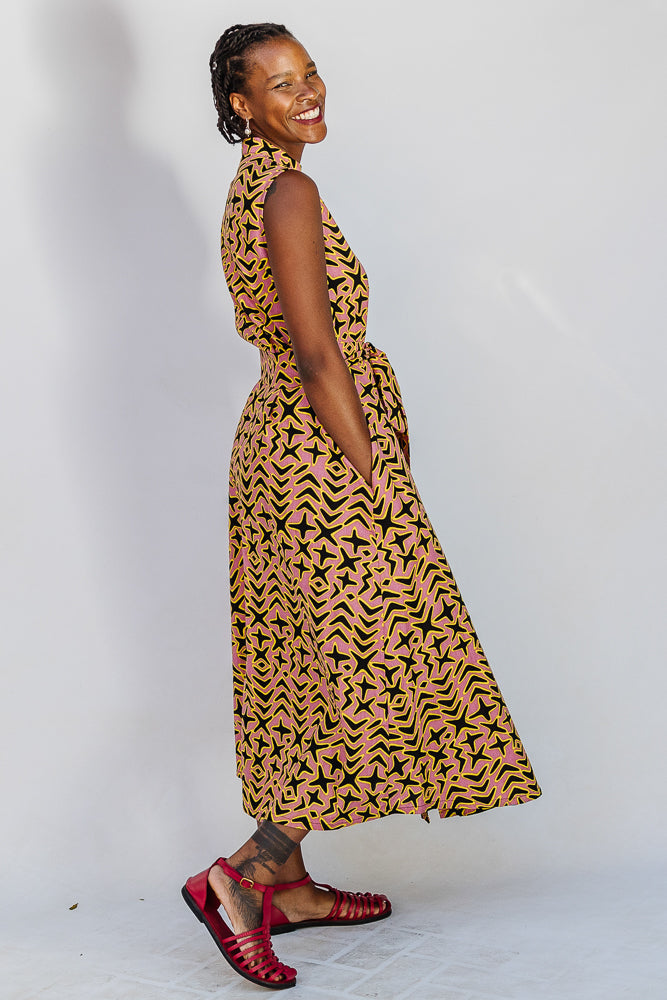 Model wearing beige, yellow and black geometric print dress.
