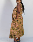 Model wearing beige, yellow and black geometric print dress.
