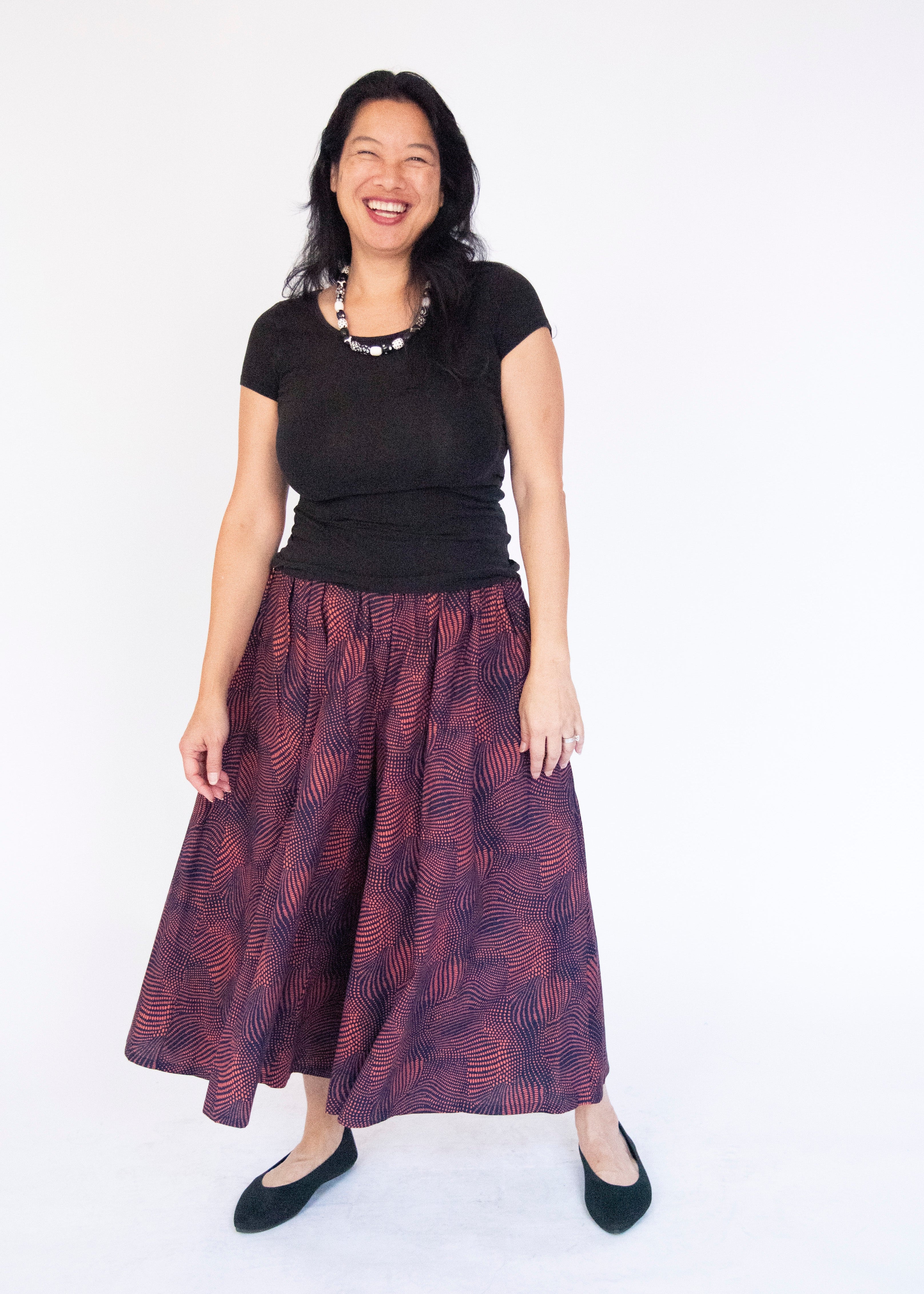Model wearing navy pants with pink dots.