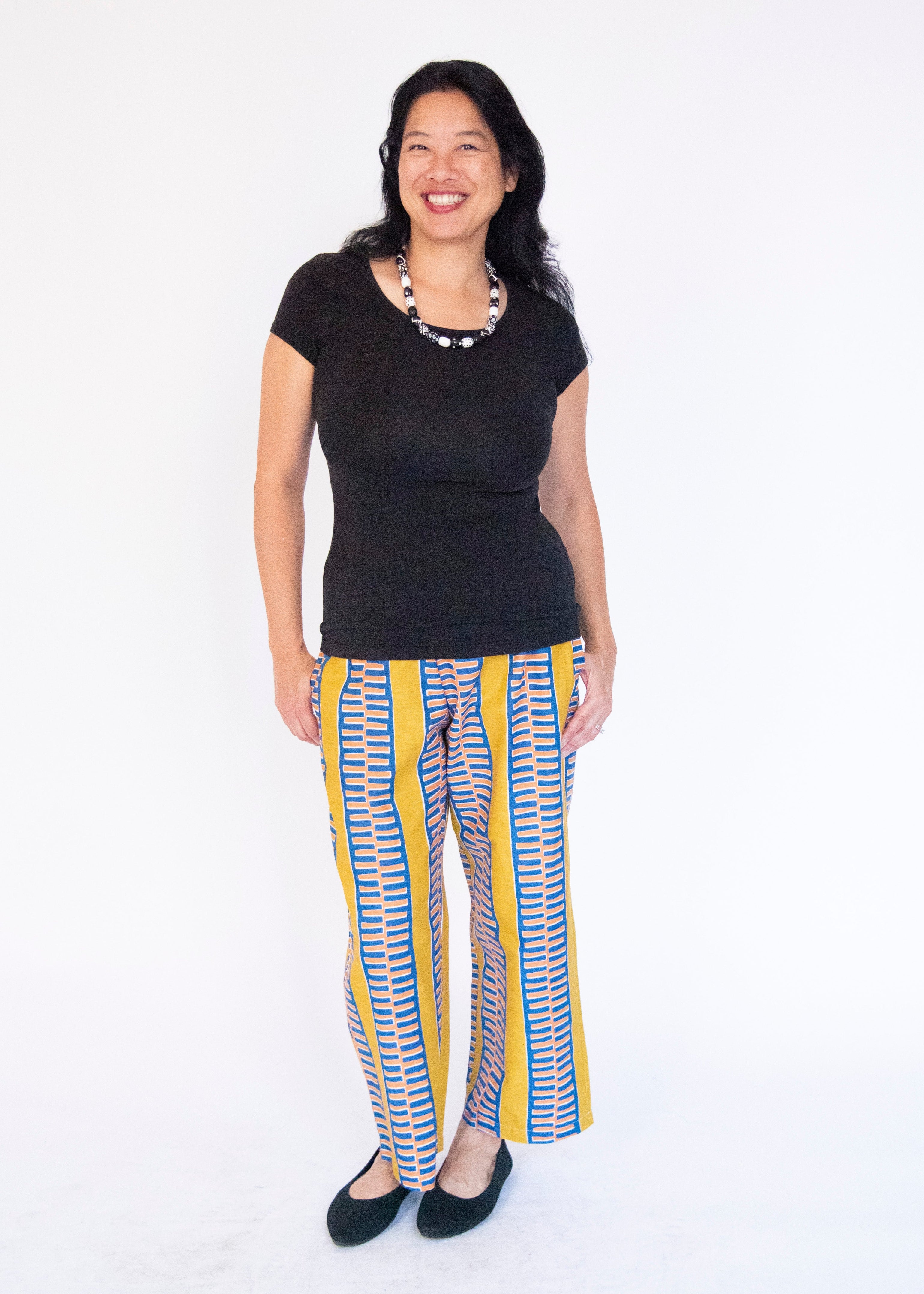 Model wearing yellow pants with blue zig zag pattern.