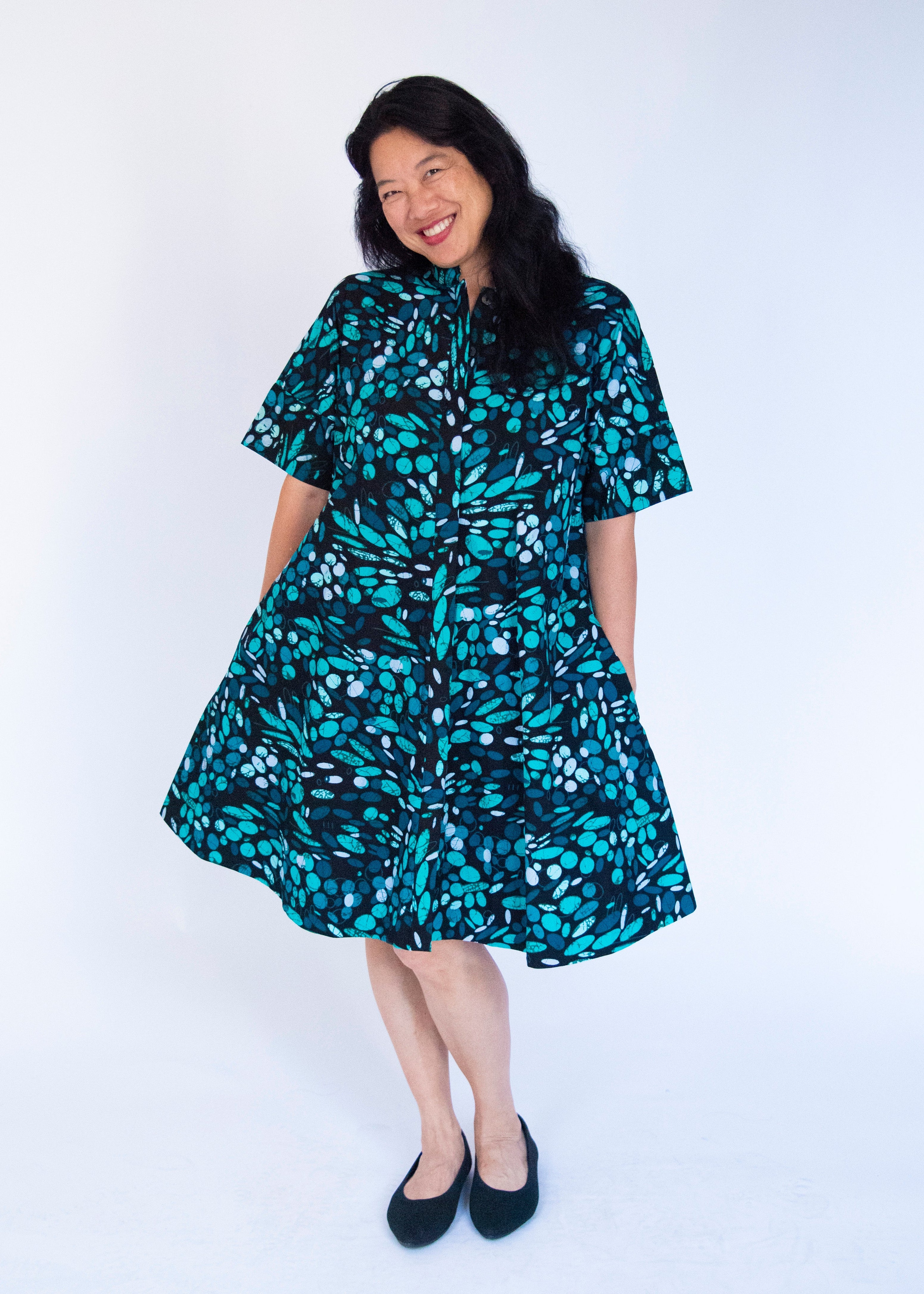 Model wearing abstract blue pebble print dress.