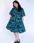 Model wearing abstract blue pebble print dress.