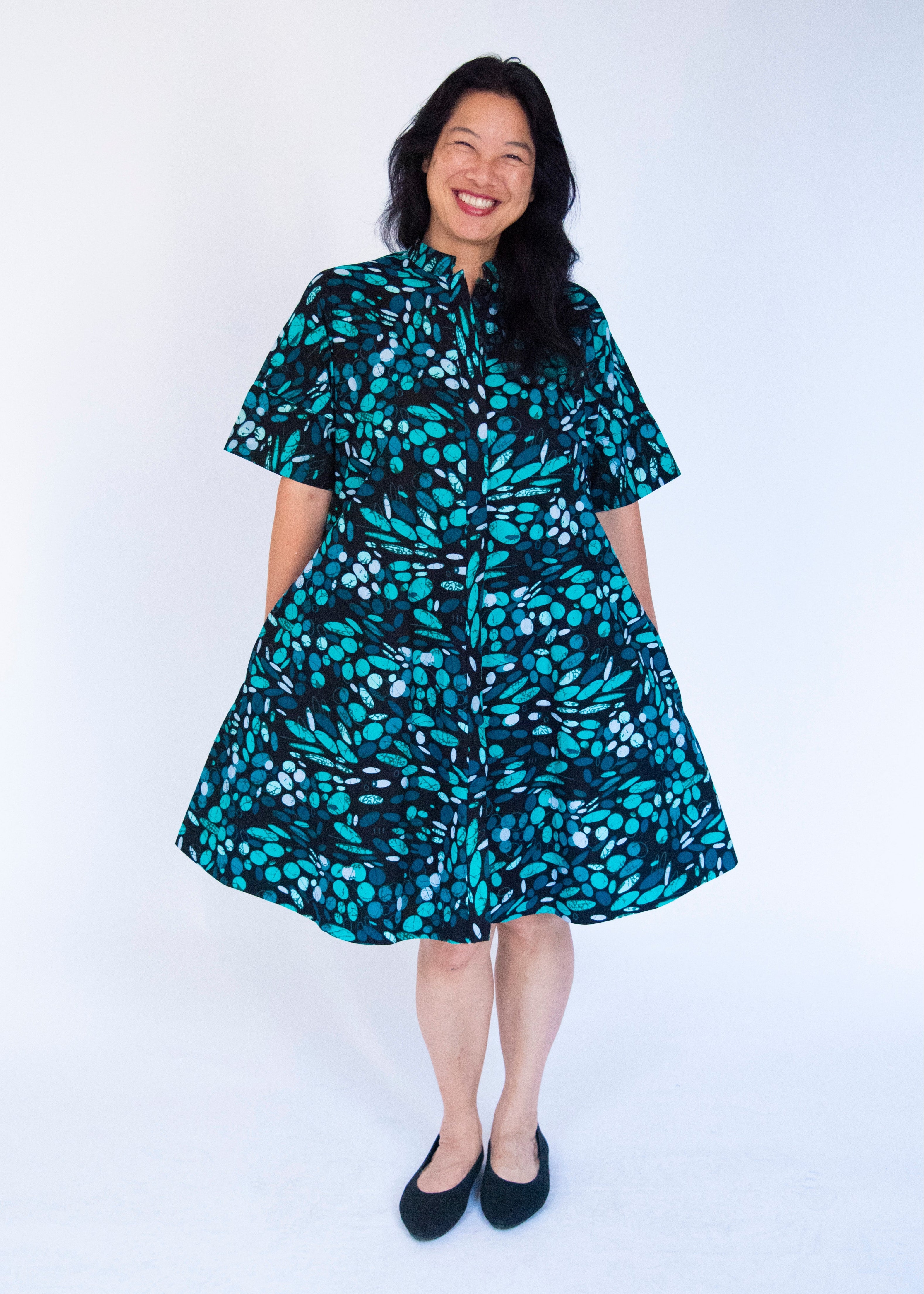 Model wearing abstract blue pebble print dress.