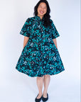 Model wearing abstract blue pebble print dress.