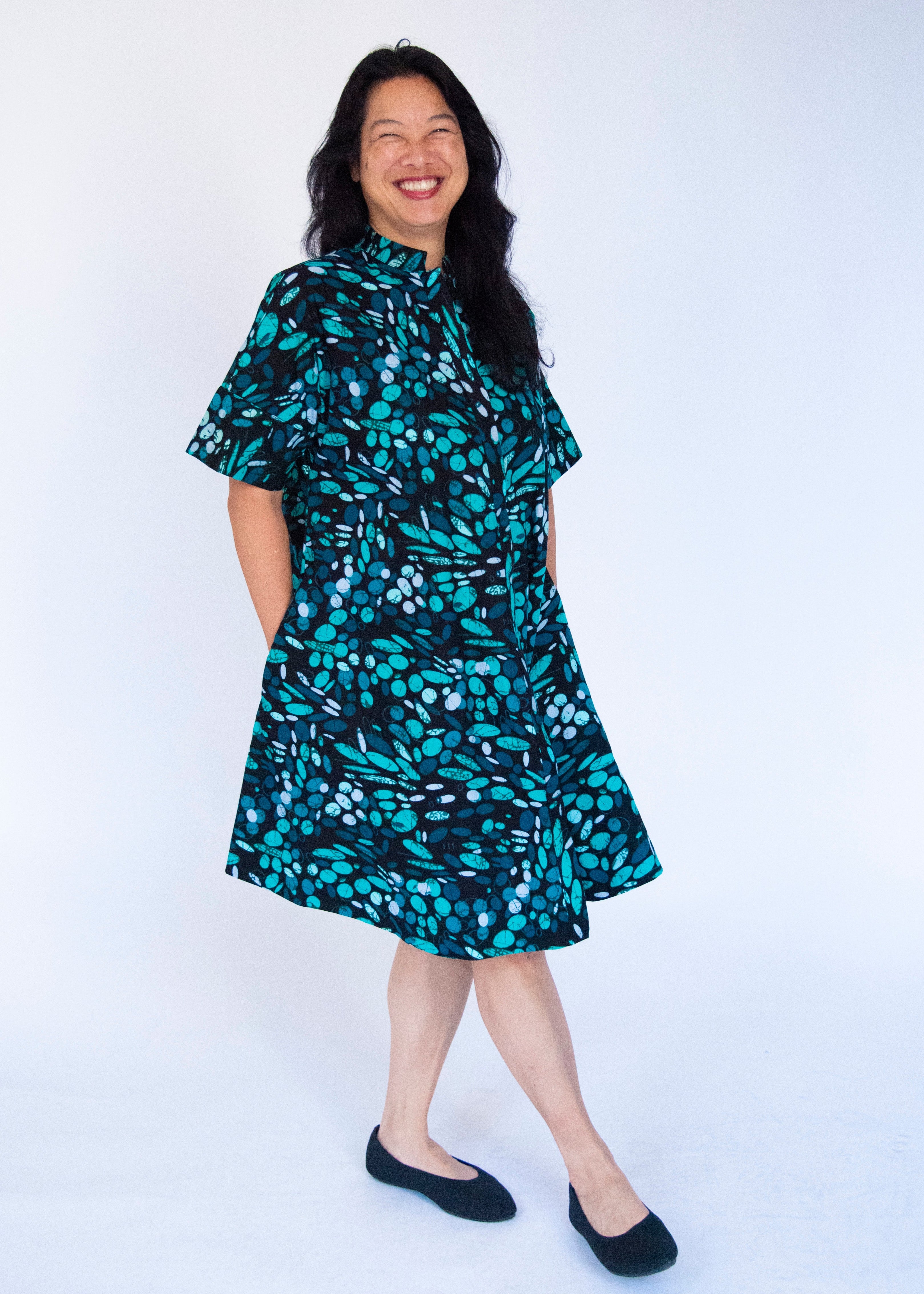 Model wearing abstract blue pebble print dress.