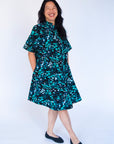 Model wearing abstract blue pebble print dress.