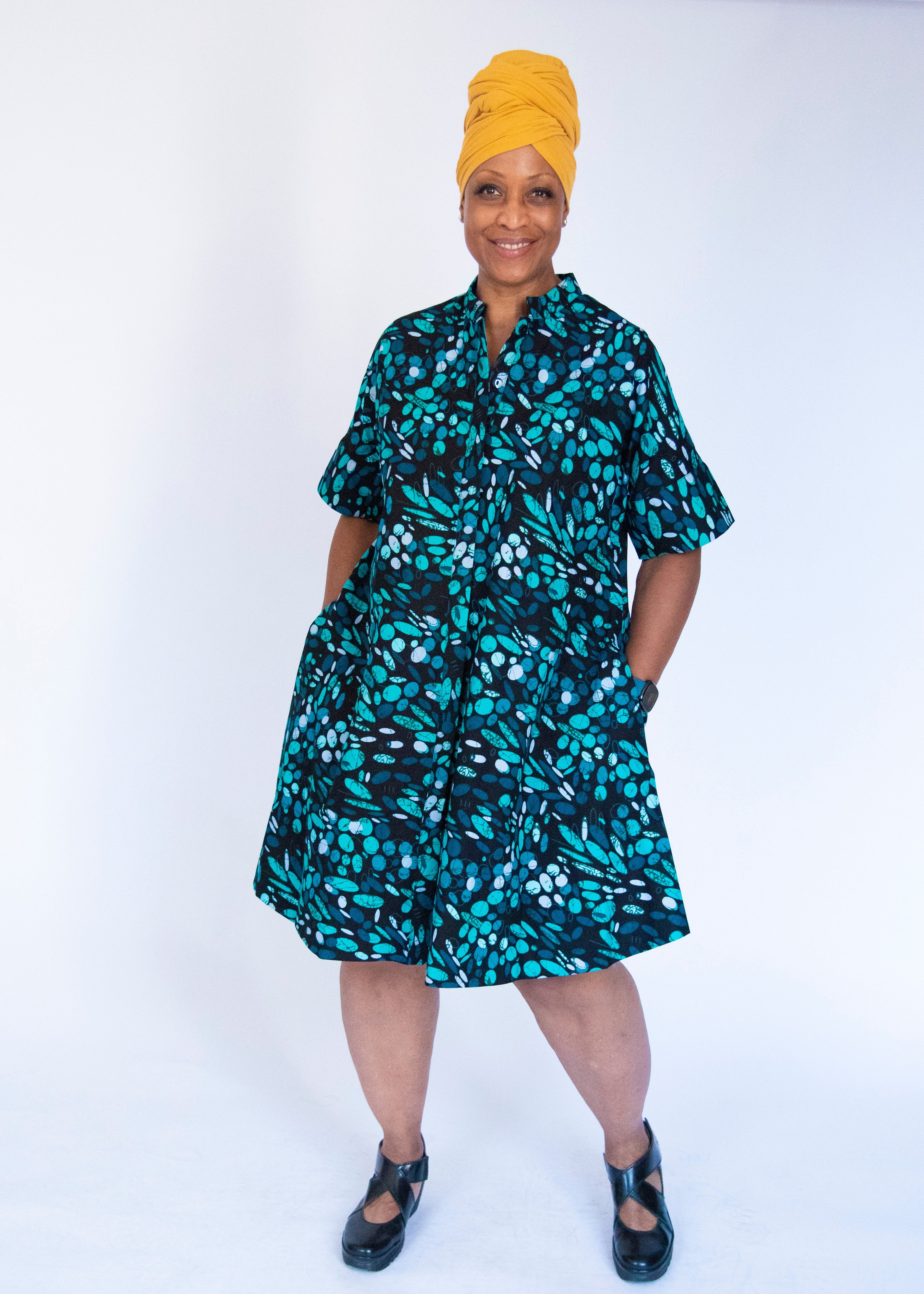 Model wearing abstract blue pebble print dress.