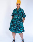 Model wearing abstract blue pebble print dress.
