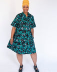 Model wearing abstract blue pebble print dress.