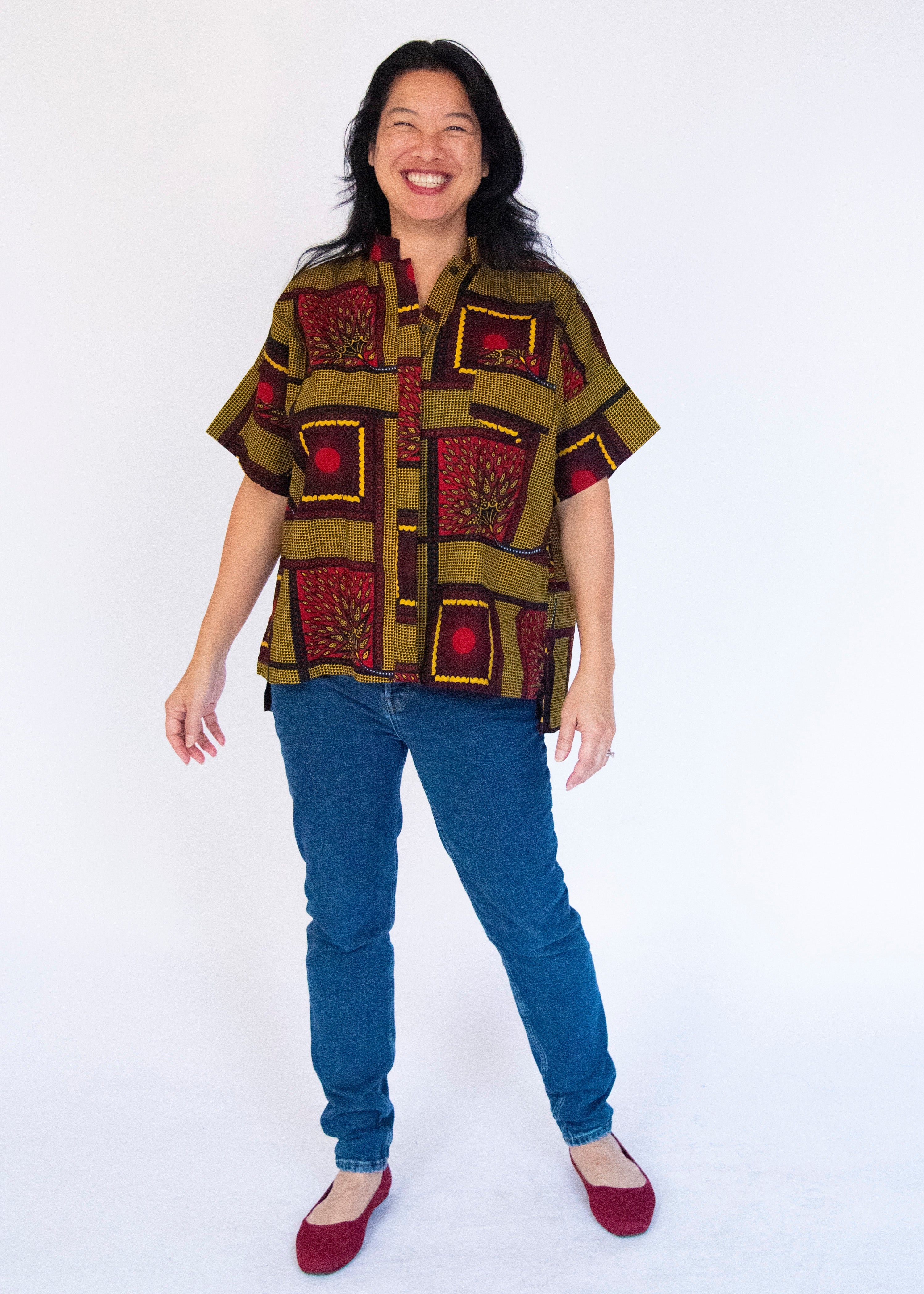 Model wearing yellow, red and black abstract print shirt.