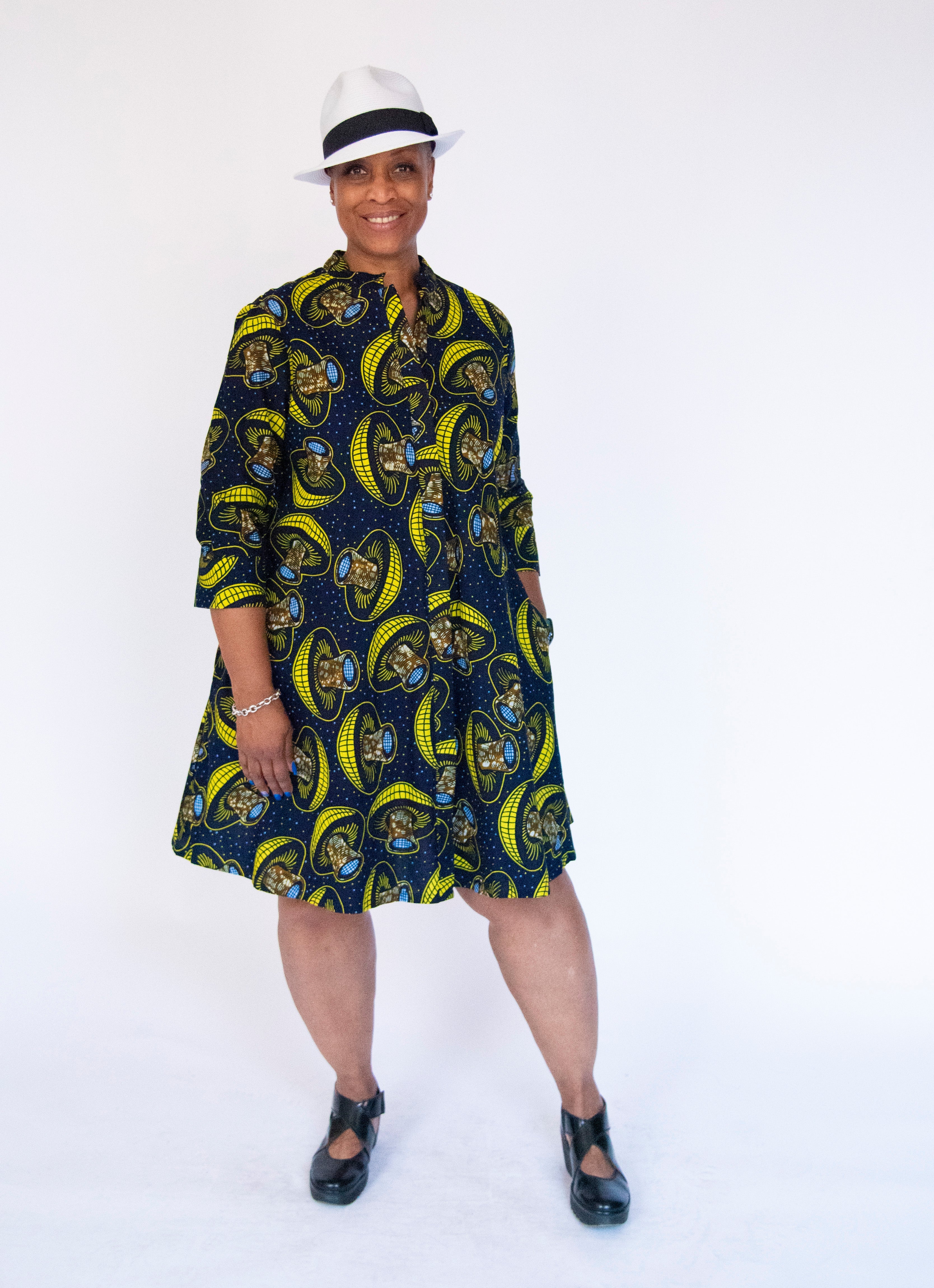 Model wearing navy dress with yellow and brown mushroom print.
