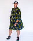 Model wearing navy dress with yellow and brown mushroom print.