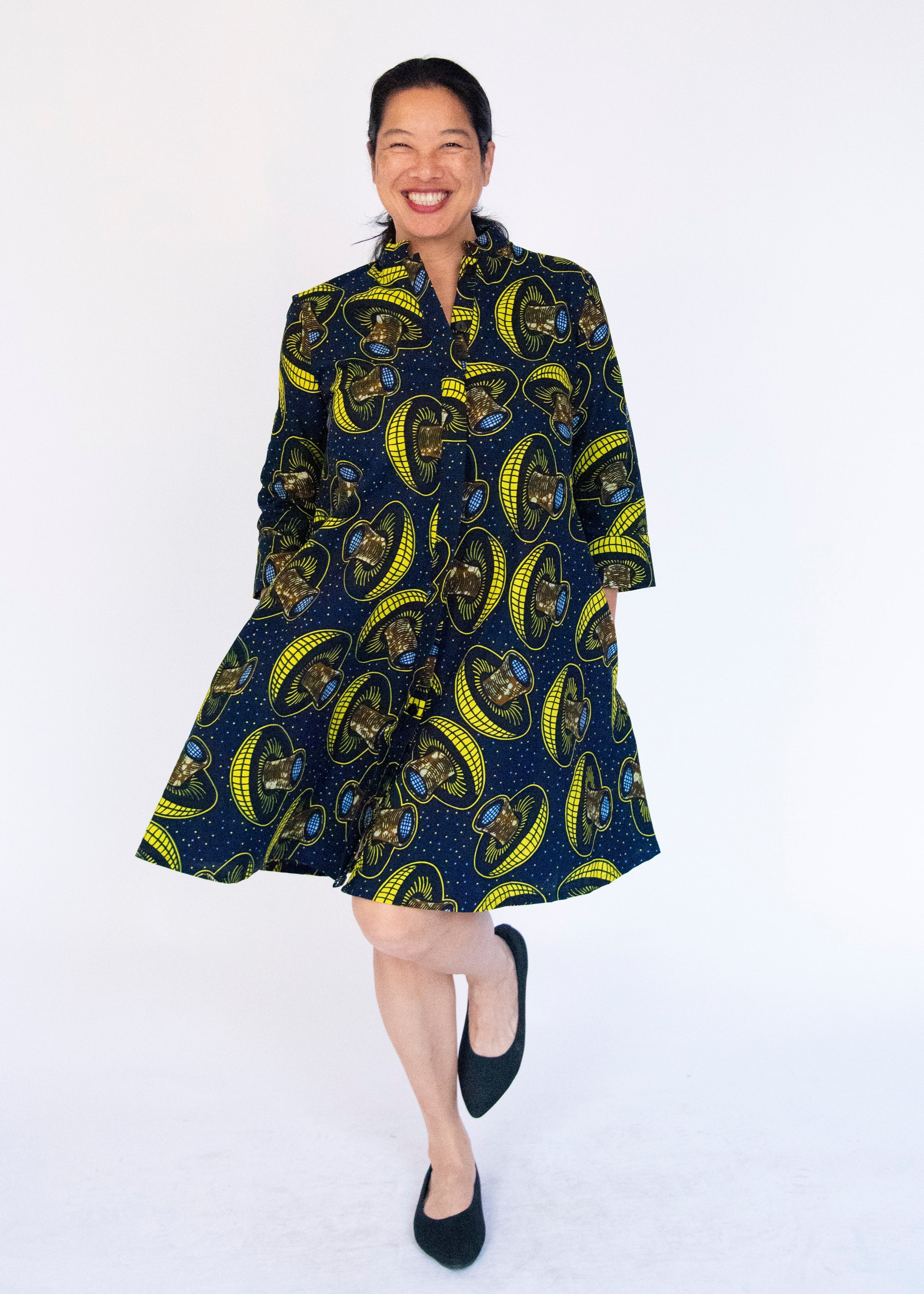 Model wearing navy dress with yellow and brown mushroom print.