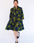 Model wearing navy dress with yellow and brown mushroom print.