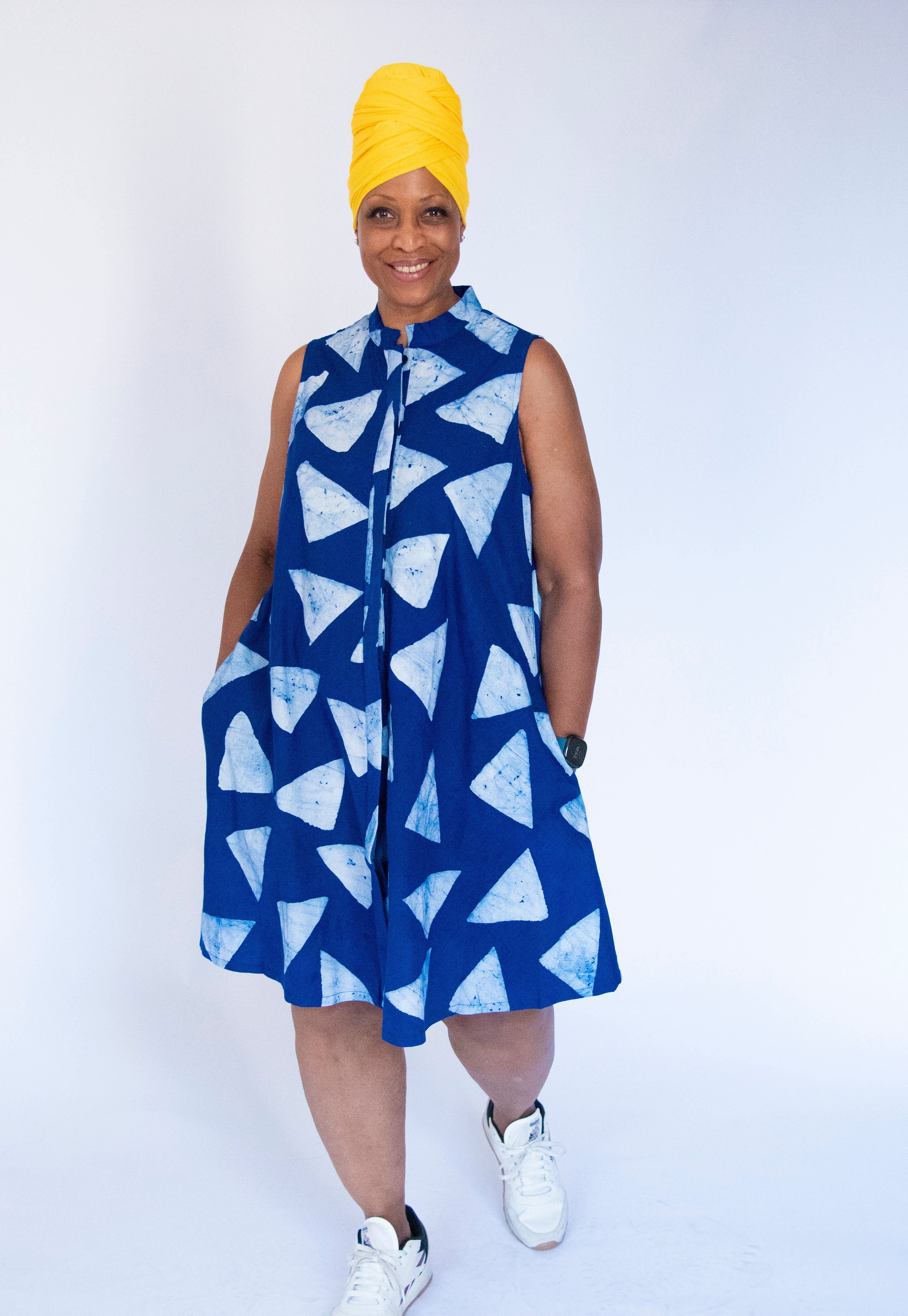 Model wearing blue sleeveless dress with white triangle print.