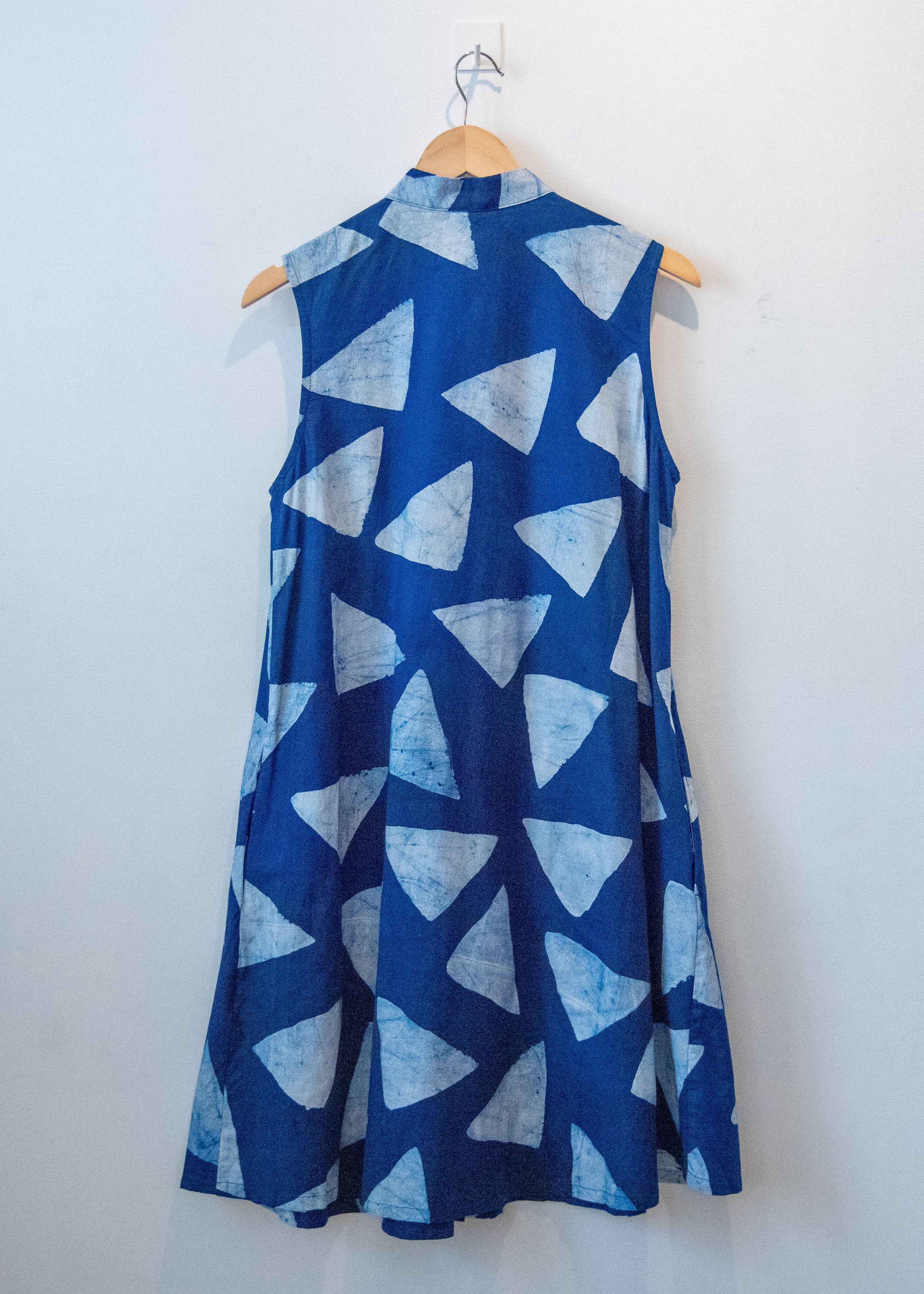 Display of blue sleeveless dress with white triangle print.